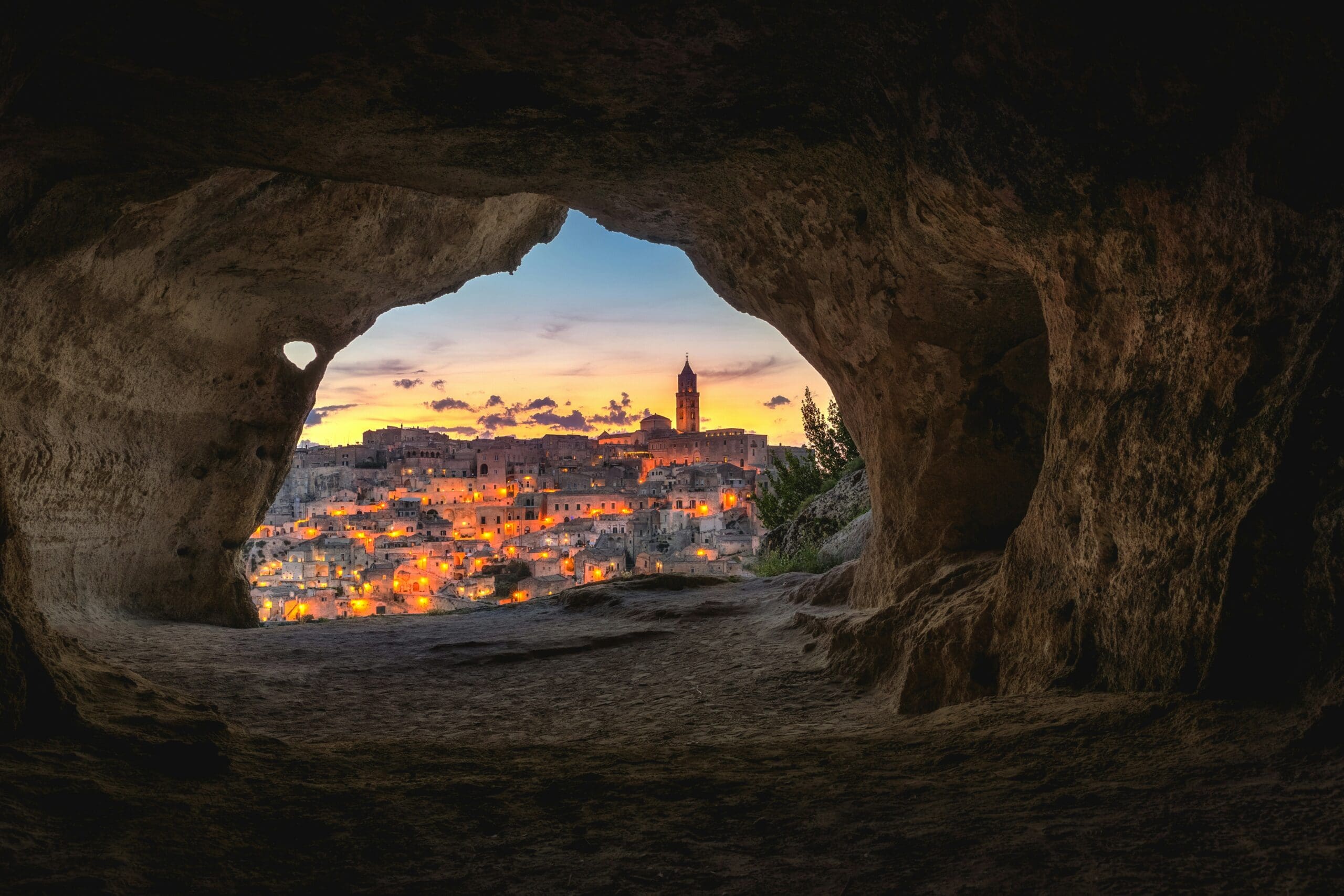 Evening view of Matera's ancient cave dwellings, softly lit under a twilight sky.